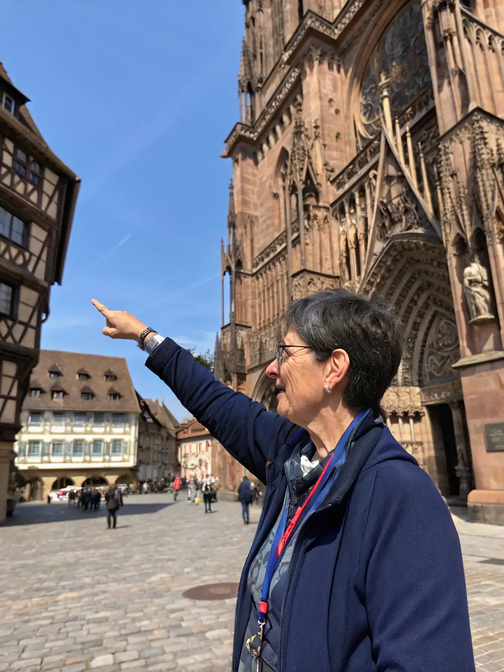 A photograph of a guided tour group outside the Maison des Templiers, with the guide pointing out architectural details and sharing historical insights, promoting the museum's guided tour service.